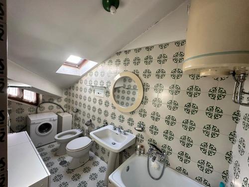 a bathroom with a sink toilet and a mirror at Trilocale Einaudi Bardonecchia in Bardonecchia