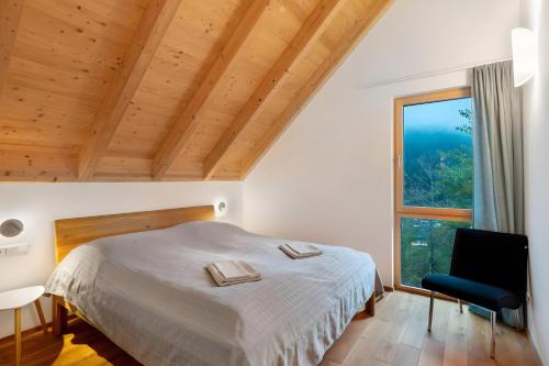a bedroom with a bed and a large window at Lug ins Tal - Ferienhaus in Baiersbronn