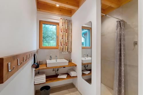 a bathroom with two sinks and a shower at Lug ins Tal - Ferienhaus in Baiersbronn