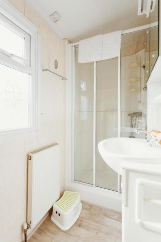 a white bathroom with a sink and a shower at Villa Hexenholz in Thale