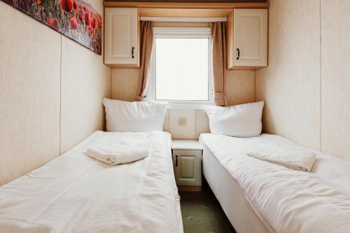 two beds in a small room with a window at Villa Hexenholz in Thale