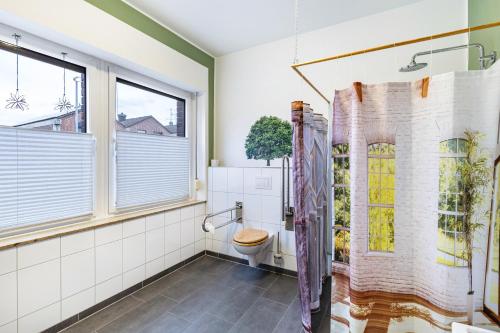 a bathroom with a toilet and a window at Garten Apartment in Kerken
