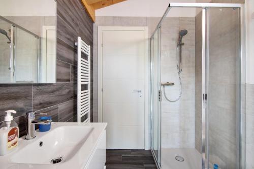 a white bathroom with a shower and a sink at Jack House in Domaso