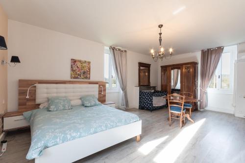a bedroom with a bed and a table and chairs at La Maison Du Soleil L'aulhère in Oloron-Sainte-Marie