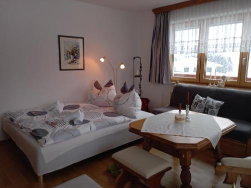 a living room with a large bed and a table at Ferienwohnung Lienbacher in Abtenau