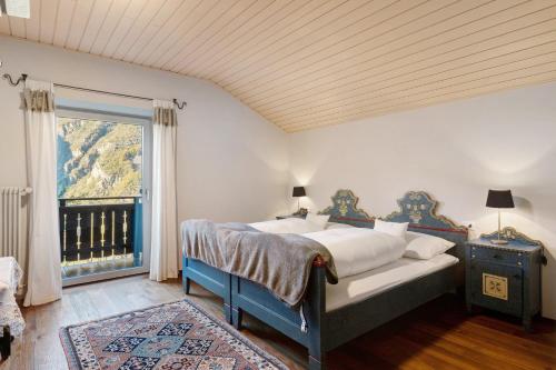 a bedroom with a bed and a large window at Alter Fausthof in Fie allo Sciliar