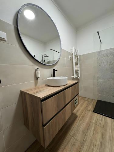 a bathroom with a sink and a large mirror at Casa d’ avó Lita in Falcoeiras