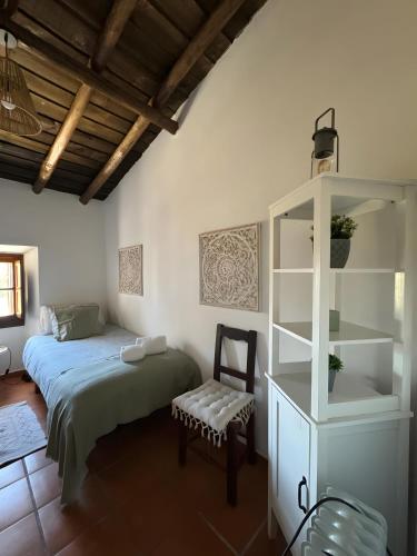 a bedroom with a bed and a cabinet and a chair at Casa d’ avó Lita in Falcoeiras