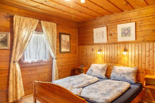 a bedroom with a bed in a log cabin at Grashäusl in Grainau