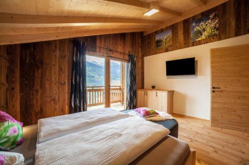 a bedroom with a bed and a large window at Bergchalet Heidi und Peter in San Leonardo in Passiria