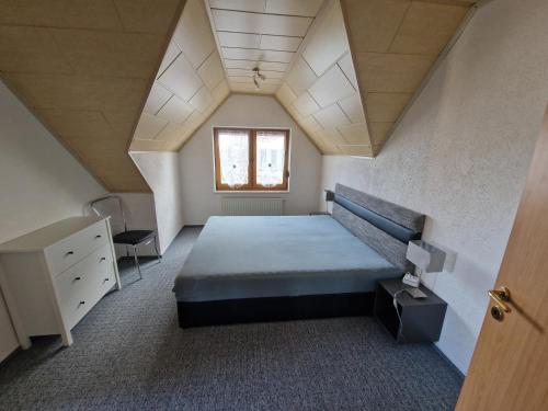 a bedroom with a large bed and a window at Ferienwohnung Auenweg in Radebeul