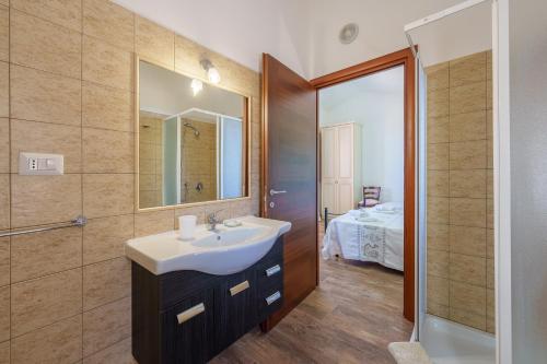 a bathroom with a sink and a mirror at Casa Mirto con piscina e vista mare in Aglientu