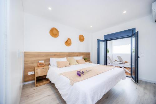 a bedroom with a large white bed with flowers on it at White suites in Cala d´Or