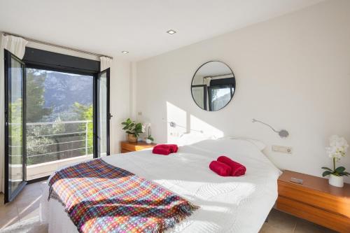 a bedroom with a bed with red pillows and a mirror at Mountain View Villa in Bárig