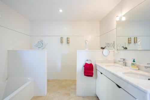 a white bathroom with two sinks and a shower at Mountain View Villa in Bárig
