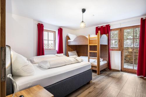 a bedroom with two bunk beds and red curtains at Good Life Top 3 in Saalbach-Hinterglemm