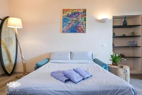 a bedroom with a bed with two purple pillows at Pieds Dans L'eau - Bogliasco in Bogliasco