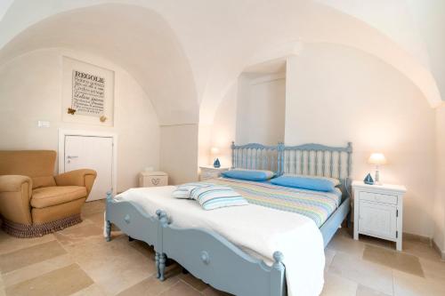 a bedroom with a blue bed and a chair at Agrumeto sul mare in Ostuni