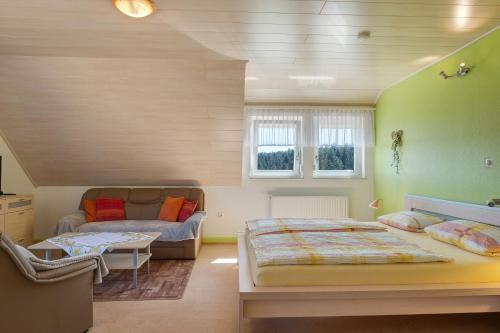 a bedroom with a bed and a couch at Unterfalkenhof in Schramberg