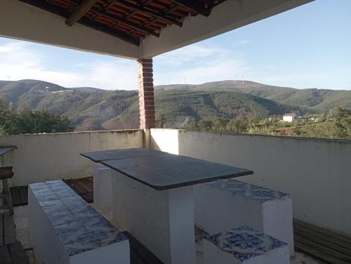 a table on a balcony with a view of mountains at Refúgio da Montanha in Sobral
