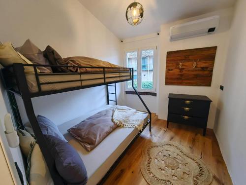 a bedroom with a bunk bed and a window at Casa Storica Gardola in Tignale