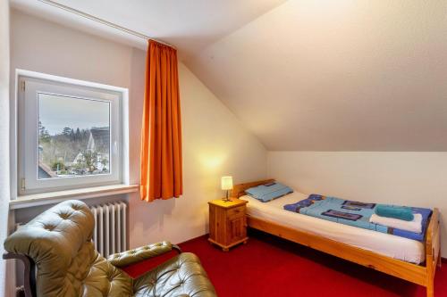 a small bedroom with a bed and a window at Haus Waldblick in Bad Berleburg