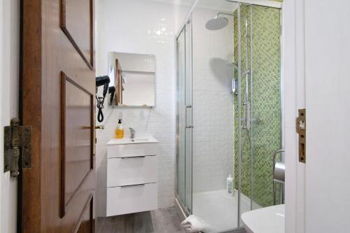 a white bathroom with a shower and a sink at Apartamento nº2 - Seashel in Moncarapacho