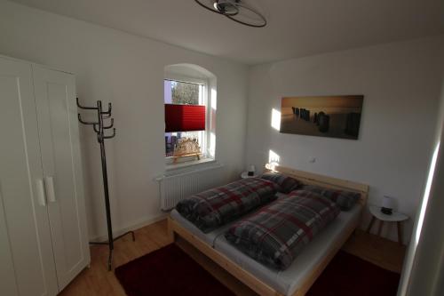 a bedroom with a bed in a room with a window at Ferienwohnung am Bärenstein in Bärenstein