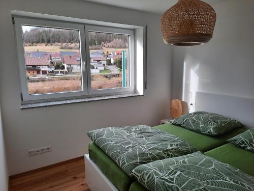 a bedroom with a bed and a large window at Ferienwohnung Im Eyachtal in Albstadt