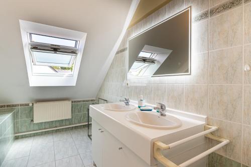 a bathroom with two sinks and a mirror at Ty Gwen in Ploeren
