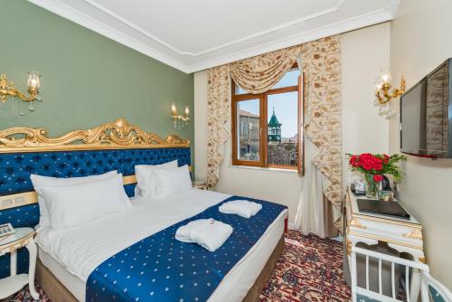 a bedroom with a blue and white bed and a window at Galatower Hotel in Istanbul