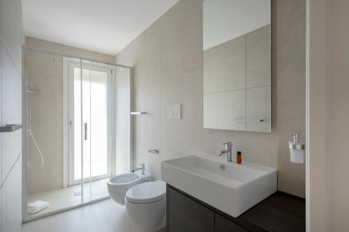 a white bathroom with a sink and a toilet at Luxury Home in Bari