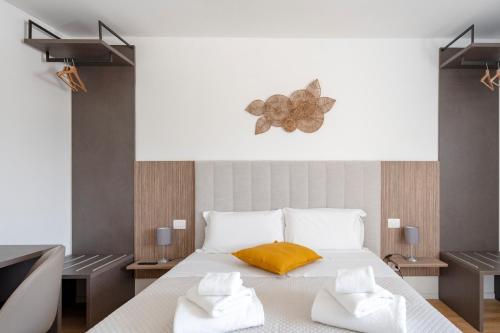 a bedroom with a white bed with a yellow pillow at Luxury Home in Bari