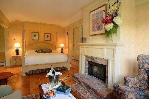 a living room with a bed and a fireplace at Windham Hill Inn in West Townshend