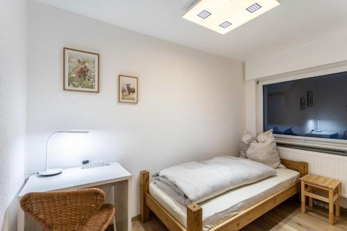 a bedroom with a bed and a desk and a window at Fuchsbau Voßwinkel in Arnsberg