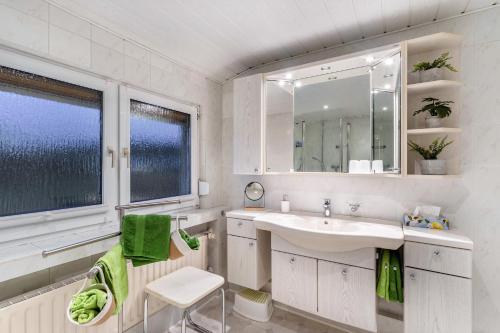 a white bathroom with a sink and a mirror at Fuchsbau Voßwinkel in Arnsberg