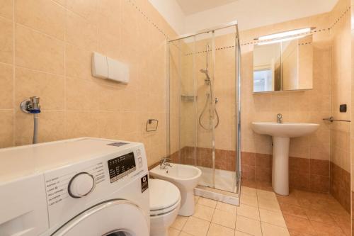 a bathroom with a toilet sink and a washing machine at Villa Bornico Marisa in Toscolano Maderno
