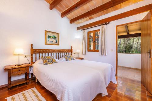 a bedroom with a white bed and a window at Can Seguinot D'alt in Pollença