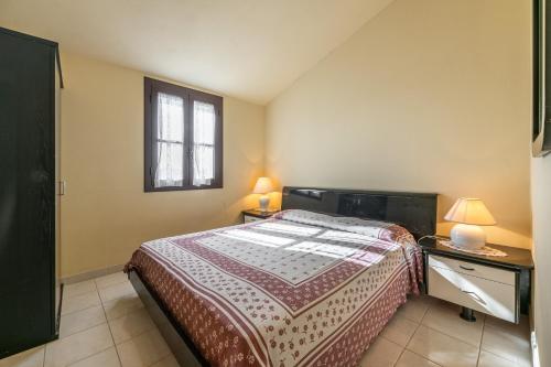 a bedroom with a bed and two tables with lamps at Via Mazzini 87 in Calasetta