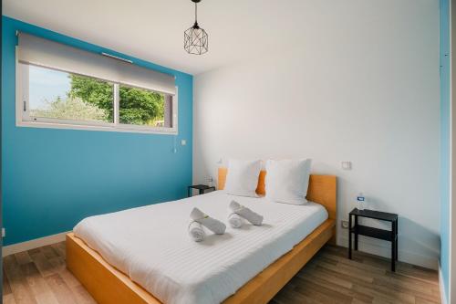 a bedroom with a bed with blue walls and a window at Villa de standing piscine 10 pers in Bruz