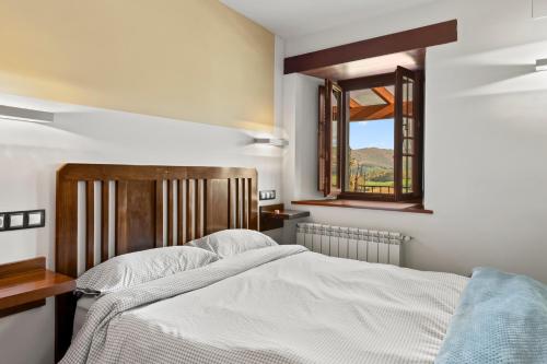 a bedroom with a bed and two windows at R de Alborada del eo in Villameitide