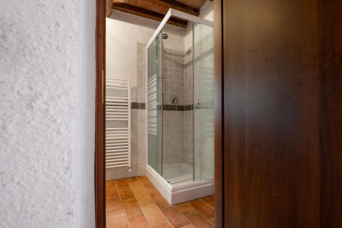 a glass shower with a glass door in a bathroom at Casetta di Ugolino in Radicofani