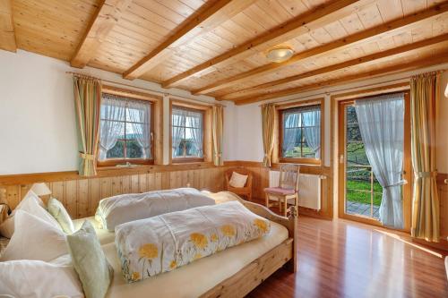 a bedroom with two beds in a room with wooden ceilings at Krährbauernhof mit Hofladen in Hornberg