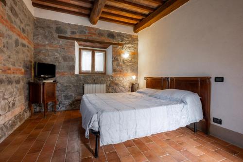a bedroom with a bed and a television in a room at Casetta di Ugolino in Radicofani