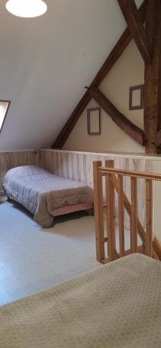a bedroom with a bed in a attic at La Maisonnette du Meslay in Fyé