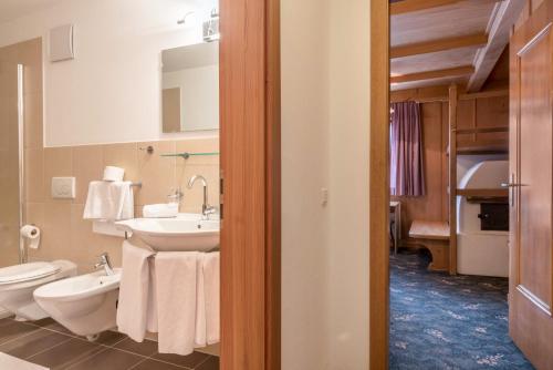 a bathroom with a sink and a toilet and a mirror at Sabina Dolomites Spitzbühl in Alpe di Siusi