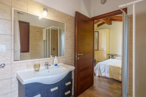 a bathroom with a sink and a mirror at Stella Marina Piscina e Vista Mare in Aglientu