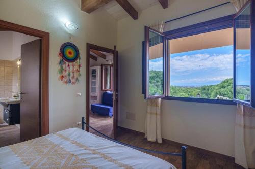 a bedroom with a bed and a large window at Stella Marina Piscina e Vista Mare in Aglientu