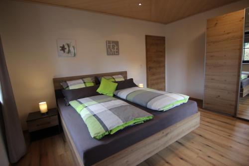 a bedroom with a large bed with green and white pillows at Ferienwohnung Oberpfälzer Wald in Vohenstrauß