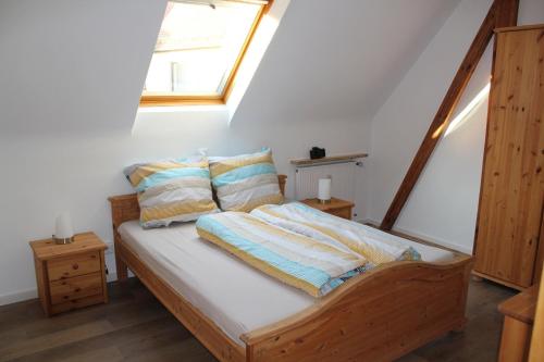 a bedroom with a bed with pillows and a window at Ferienwohnung Am Wehr in Georgensgmünd